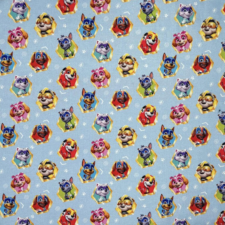 A colorful pattern featuring cartoon puppy characters wearing various uniforms, including blue, red, yellow, and pink outfits. The puppies have expressive faces and are set against a light blue background with white paw prints and patterns scattered throughout.