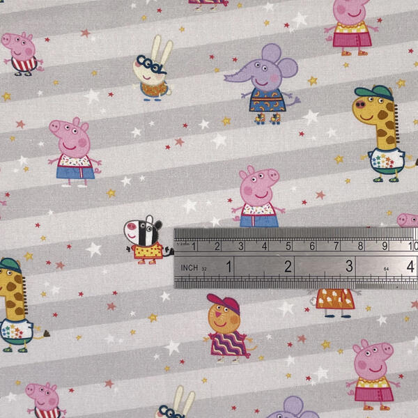 A patterned fabric features various cartoon animals, including pigs, a rabbit, an elephant, a zebra, a giraffe, and a snail, all casually dressed and spaced out on a grey background with diagonal white stripes and scattered colorful stars. A metal ruler shows scale.