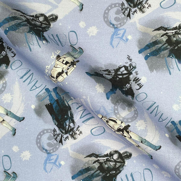 Fabric pattern featuring illustrations of armored figures and the word "MANDO". The background includes subtle snowflakes and light blue hues. The figures vary in pose and style, suggesting a sci-fi or adventure theme.