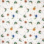 A patterned fabric featuring illustrations of caterpillars, apples, plums, and oranges, interspersed with colorful polka dots on a white background. The design is playful and vibrant, evoking a children's theme.