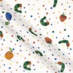 White fabric with colorful illustrations of the Very Hungry Caterpillar, an apple, a strawberry, a plum, and small dots in various colors scattered across the fabric. The caterpillar is depicted in different positions and orientations.
