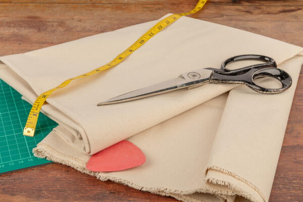 Canvas Fabric being shown in greater detail in a sewing room with craft scissors.