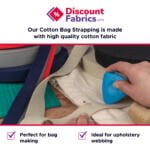 A hand is using a blue tool to flatten seams on beige cotton webbing fabric. Various rolls of fabric in different colors are on a cutting mat. Text on the image reads: "Discount Fabrics LTD. Our Cotton Bag Strapping is made with high quality cotton fabric. Perfect for bag making. Ideal for upholstery webbing.