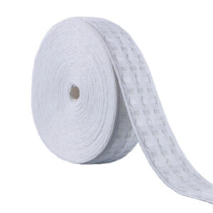 A large roll of white decorative trim, featuring a subtle grid pattern design. The trim is wound tightly in a cylindrical shape, with one end slightly unraveled and laid out flat, displaying the pattern.