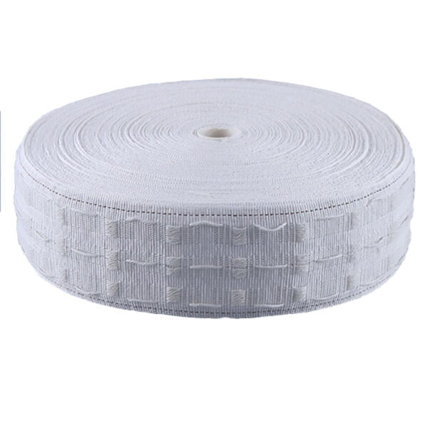 A roll of white elastic band with a textured pattern is shown on a plain background. The band is coiled neatly, displaying its width and the intricate design along its length. The spool has a small cylindrical hole in the center.