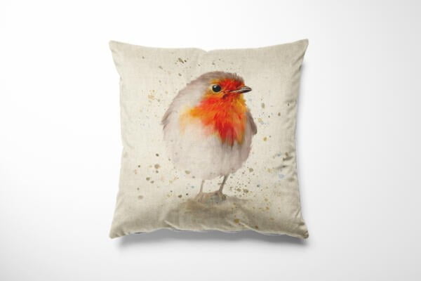 A decorative cushion with a beige background featuring a detailed illustration of a robin. The bird, with its characteristic red breast and brownish-grey feathers, stands out against a subtly speckled backdrop.