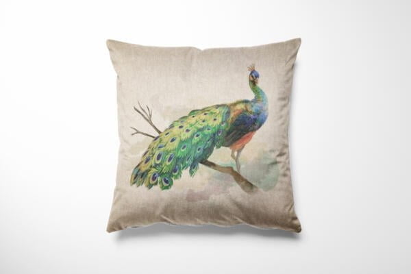 A decorative throw pillow with an artistic design of a peacock standing on a branch. The bird's iridescent blue and green feathers are prominently displayed on the light beige fabric, creating a visually striking and elegant accent piece.