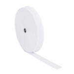 A large roll of white elastic band with a small metal core visible at the center. The roll stands upright and a portion of the elastic band is unrolled and lying flat. The background is plain white.