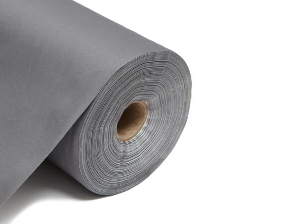 This image shows a roll of blackout lining fabric. The fabric is neatly rolled around a central cardboard tube, revealing multiple layers tightly wound together. The fabric has a smooth, matte finish and is displayed on a clean, white background that emphasizes its uniform color and texture. The edge of the roll is cleanly cut, highlighting the fabric's thickness and durability. The colour of this lining is charcoal