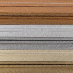 A close-up image of multiple horizontal layers of textured fabric in various shades, including brown, silver, gold, and gray. The fabrics are neatly stacked on top of each other, highlighting their varied colors and textures.