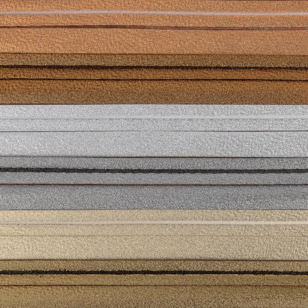A close-up image of multiple horizontal layers of textured fabric in various shades, including brown, silver, gold, and gray. The fabrics are neatly stacked on top of each other, highlighting their varied colors and textures.