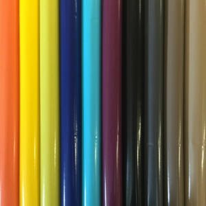 A close-up image of colorful rolls of vinyl arranged vertically. The colors, from left to right, include bright red, orange, light orange, yellow, bright yellow, blue, cyan, turquoise, purple, black, dark grey, grey, light grey, and white.