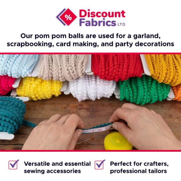 A person measuring teal pom-pom trim with a measuring tape, surrounded by various colors of pom-pom bundles on wooden surface. "Discount Fabrics LTD" logo and text above, describing use in garlands, scrapbooking, card making, and party decorations.
