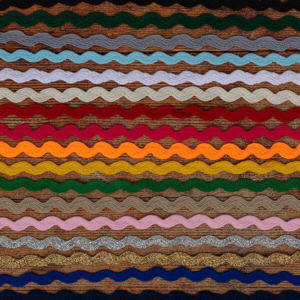 A colorful textile pattern with horizontal, wavy stripes in various colors, including brown, green, blue, yellow, orange, red, and pink. The stripes have a textured appearance, giving the fabric a dynamic and visually interesting look.