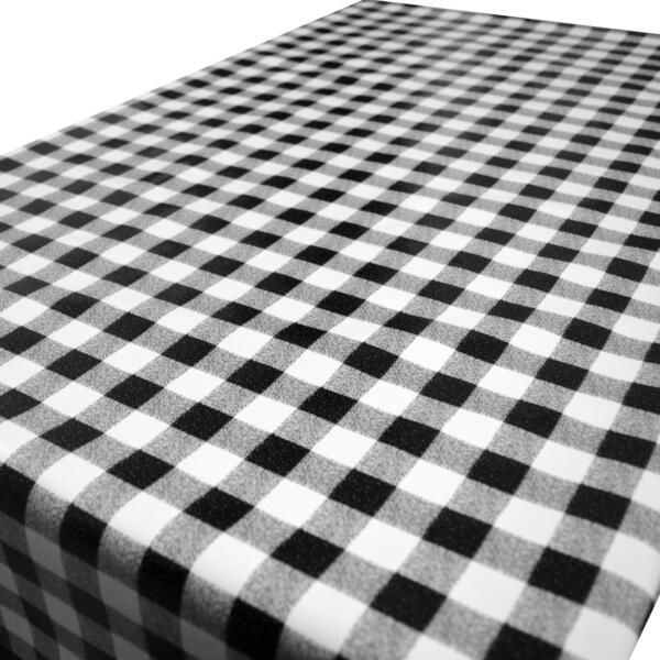 A table covered with a black and white checkered tablecloth. The checkered pattern consists of alternating black and white squares, giving the table a classic and timeless appearance.