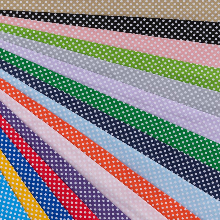 A colorful array of fabric swatches arranged in a fan pattern. Each swatch has a white polka-dot design on a different colored background, including shades like beige, black, pink, green, gray, blue, red, purple, yellow, and orange.