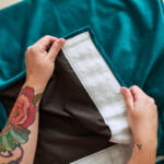 Image of a human showing a finished home sewn fabric curtain using blackout curtain lining and super velvet fabric.