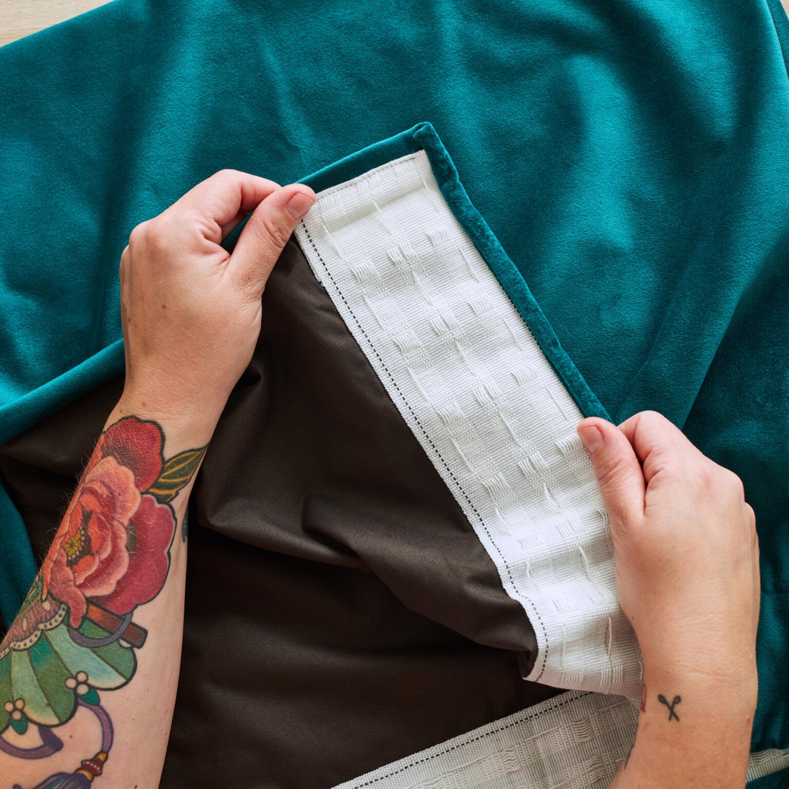 Image of a human showing a finished home sewn fabric curtain using blackout curtain lining and super velvet fabric.