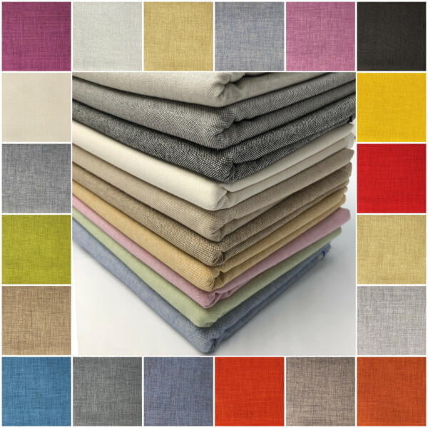 A central pile of neatly folded fabrics is surrounded by a border of different colored fabric swatches. The fabrics exhibit a range of colors including beige, brown, yellow, green, pink, blue, red, and more, displaying a textured, woven appearance.