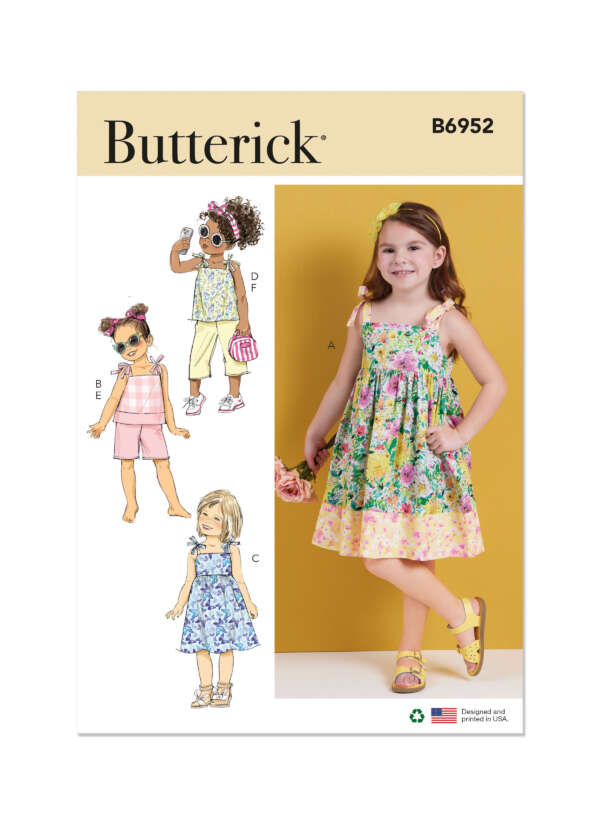 Butterick sewing pattern B6952 featuring designs for children's clothing. The cover displays four variations: a sleeveless floral dress, a pink playsuit, a floral top and skirt, and a yellow romper. A young girl models the sleeveless floral dress on the right.