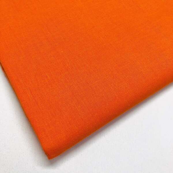 A close-up of a rectangular piece of bright orange fabric, neatly folded with visible weave texture, set against a white background.