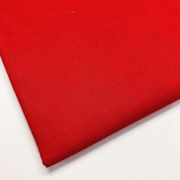 A close-up of a folded, smooth red fabric displayed on a white surface. The fabric appears tightly woven, with a solid and vibrant red color dominating the image.