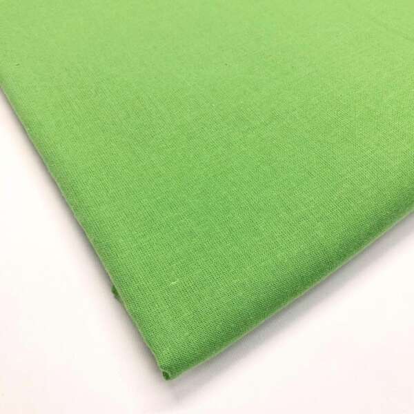 A close-up view of a neatly folded piece of bright green fabric on a white background. The fabric appears smooth and tightly woven, with a uniform texture and consistent color.