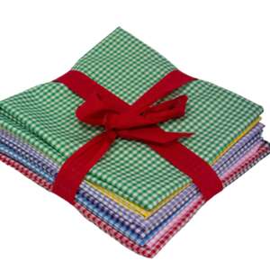 A stack of folded, colorful gingham fabric pieces tied with a red ribbon. The fabrics feature small checkered patterns in various colors, including green, blue, yellow, red, and purple. The red ribbon forms a neat bow on top of the stack.