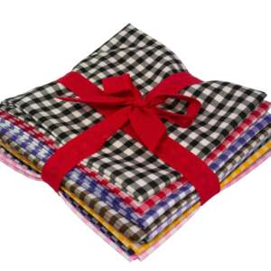 A neatly stacked bundle of colorful checkered fabric pieces, tied together with a red ribbon. The top fabric features a classic black and white checkered pattern. The other fabrics in the stack vary in colors.