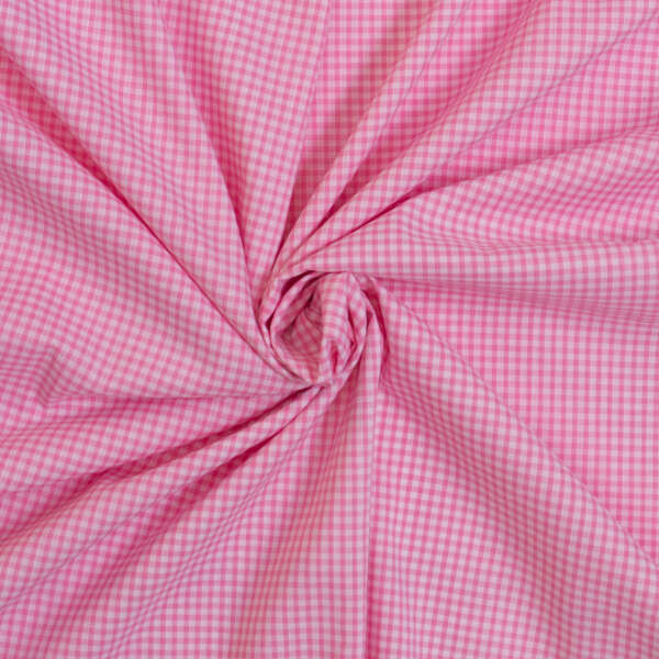 A close-up of pink and white gingham fabric, gathered into a swirl pattern. The fabric features a small, checkered design and is arranged in a circular, folded formation, creating a textured, three-dimensional appearance.