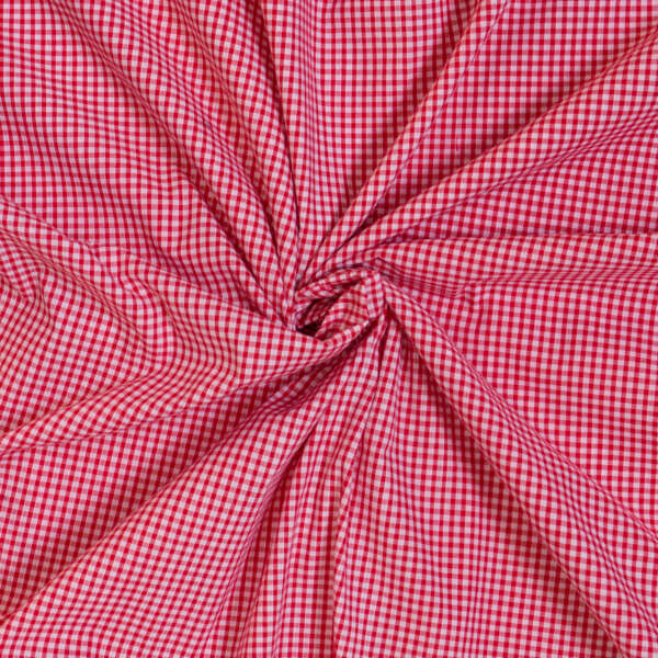 A close-up image of red and white checkered fabric, twisted in the center, creating a swirling pattern with visible folds and creases.