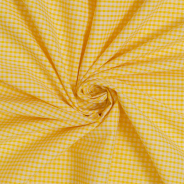 A close-up of yellow and white gingham fabric, folded and twisted in a spiral pattern. The fabric features a checkered design with small, evenly spaced squares.