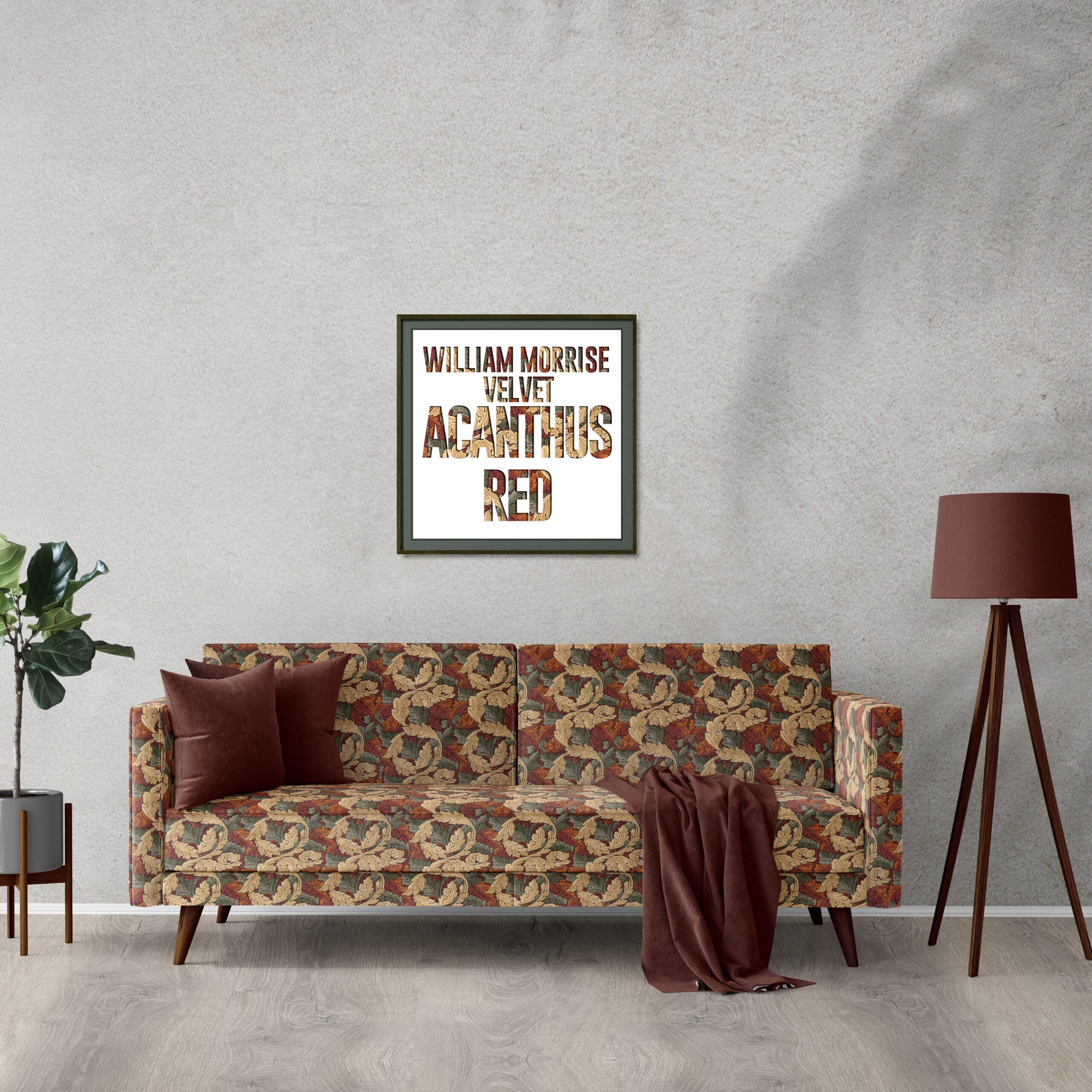 A vintage-style room with a floral-patterned sofa, a brown pillow, and a draped blanket. A potted plant is to the left, and a floor lamp to the right. Above the sofa is a framed print with the text "William Morris Velvet Acanthus Red.