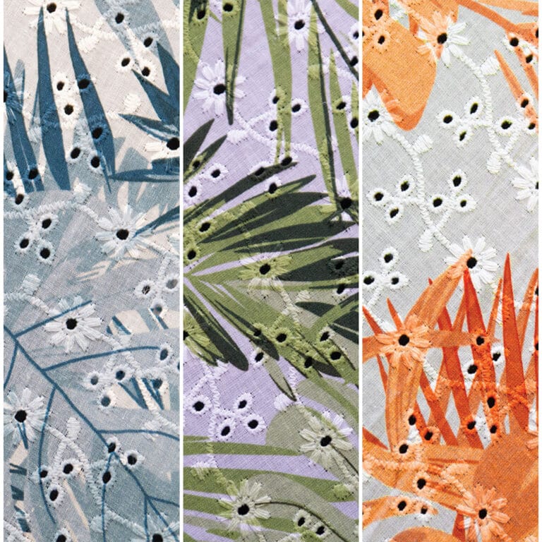 Three fabric panels with tropical leaf patterns and small embroidered flowers. The left panel has blue and gray leaves, the center has green leaves on lavender, and the right has orange leaves on light orange fabric.