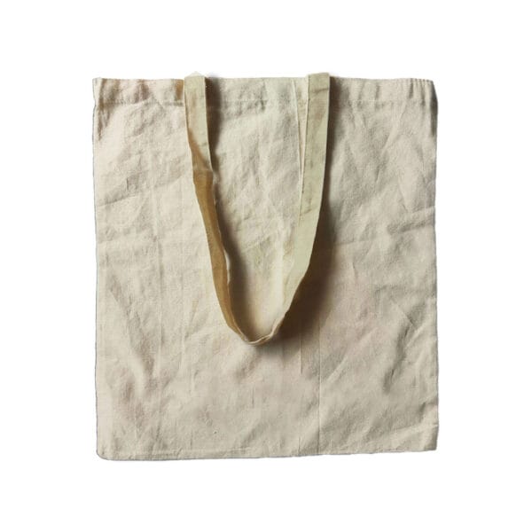 A plain, light beige canvas tote bag with two handles, lying flat on a white background. The bag is simple and unadorned, highlighting its textured fabric.