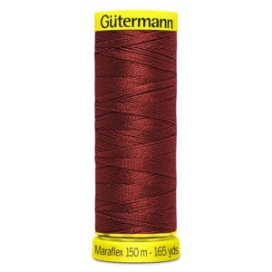 A spool of Gütermann Maraflex thread in dark red, labeled with "150 m - 165 yds" on a yellow base.