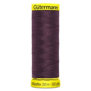 A spool of Gütermann Maraflex thread, 150 meters (165 yards) long, in a dark purple color. The spool has a bright yellow base and top, with the brand and length clearly labeled in black text.