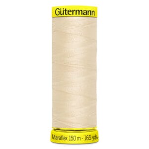 A spool of Gütermann Maraflex sewing thread, ivory-colored, with labels on top and bottom showing the brand name and 150 meters (165 yards) in length.
