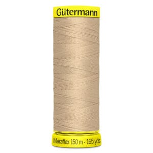 A spool of Gütermann Maraflex thread, 150 meters (165 yards), in beige color. The spool has yellow ends with the brand name printed on the top and measurement details on the bottom.
