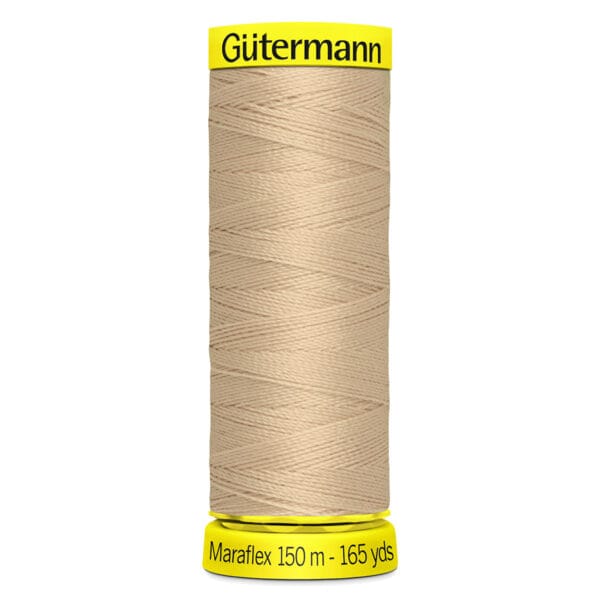A spool of Gütermann Maraflex thread, 150 meters (165 yards), in beige color. The spool has yellow ends with the brand name printed on the top and measurement details on the bottom.