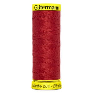 A spool of Gütermann red thread labeled "Maraflex 150 m - 165 yds" with yellow caps on the top and bottom. The thread is neatly wound around the spool.