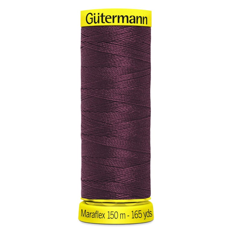 A spool of Gütermann Maraflex sewing thread in maroon is displayed. The spool has a bright yellow base and top. It contains 150 meters (165 yards) of thread.