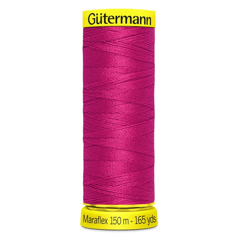 A spool of Gütermann Maraflex thread in bright pink, with "150 m - 165 yds" labeled on the bottom. The spool has yellow end caps with the brand name on top.
