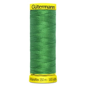 A spool of Gütermann Maraflex thread in vibrant green, with yellow bands at the top and bottom displaying the brand name and length: 150 meters (165 yards). The thread is neatly wound in a cross pattern.