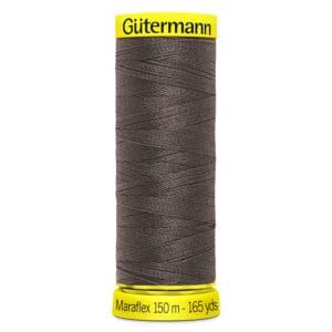 A spool of Gütermann Maraflex thread in dark gray, labeled as 150 meters or 165 yards. The spool has bright yellow ends with the brand name printed on top.