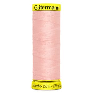 A spool of Gütermann Maraflex sewing thread in light pink is shown. The spool is labeled with "150 m - 165 yds.