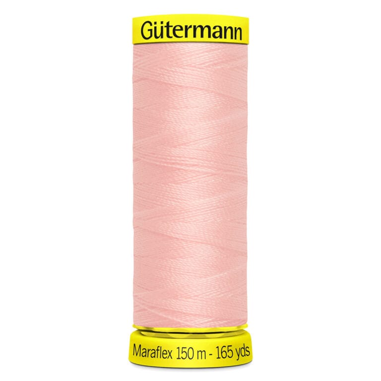 A spool of Gütermann Maraflex sewing thread in light pink is shown. The spool is labeled with "150 m - 165 yds.