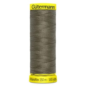 A spool of Gütermann MaraFlex thread in dark green. The spool has a yellow top and bottom, with labeling that reads "Gütermann" and "Maraflex 150 m - 165 yds.