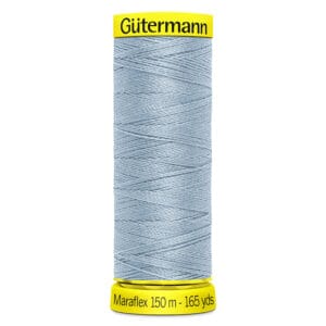 Spool of Gütermann Maraflex thread in light blue color on a yellow spool. The label indicates 150 meters (165 yards) of thread.