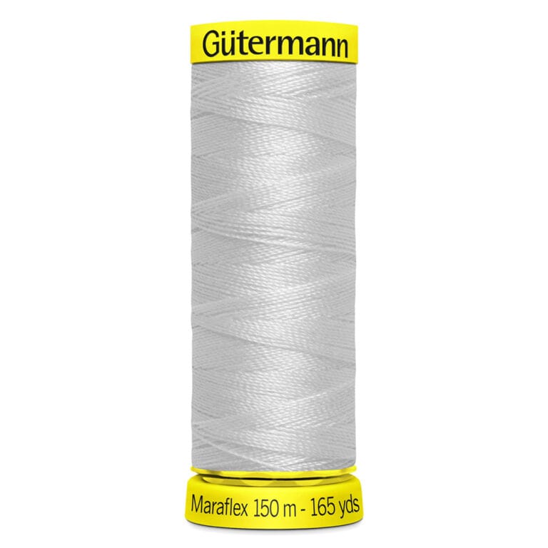 A spool of Gütermann white sewing thread labeled "Maraflex 150 m - 165 yds" with a yellow top and bottom.